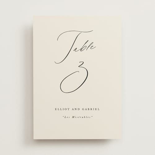 This is a ecru table numbers with standard by Hooray Creative called scripted names printing on doublethick in standard