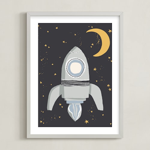 This is a muted blue kids wall art with standard by Maggie Unruh called up in space rocket ship