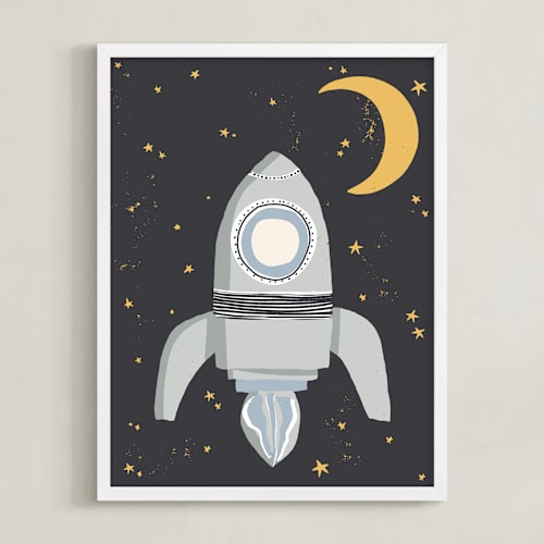 This is a muted blue kids wall art by Maggie Unruh called up in space rocket ship