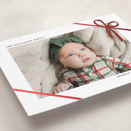 This is a marshmallow foil pressed holiday cards with foil pressed by Ekko Studio called wrapped in ribbon printing on recycled smooth signature in standard