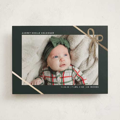 This is a spruce babys first christmas with foil pressed by Ekko Studio called wrapped in ribbon printing on recycled smooth signature in standard