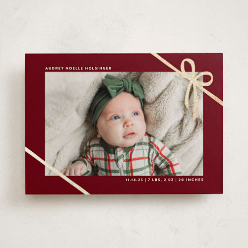 This is a cranberry babys first christmas with foil pressed by Ekko Studio called wrapped in ribbon printing on recycled smooth signature in standard