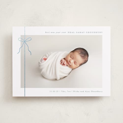 This is a french blue babys first christmas with foil pressed by Olivia Raufman called crisp bow printing on recycled smooth signature in standard