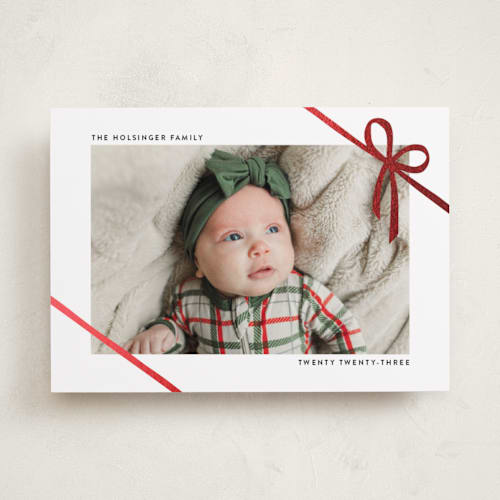 This is a marshmallow foil pressed holiday cards with foil pressed by Ekko Studio called wrapped in ribbon printing on recycled smooth signature in standard