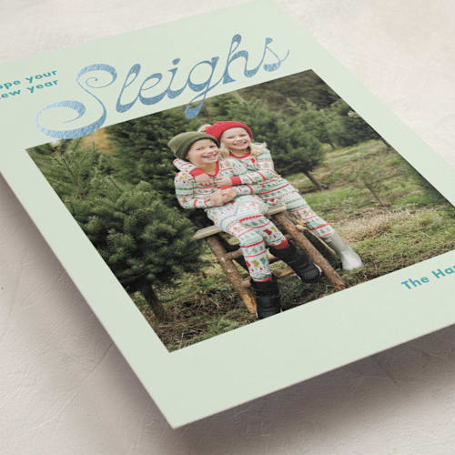 This is a turquoise foil pressed holiday cards with foil pressed by Megan Davis called sleighs printing on recycled smooth signature in standard