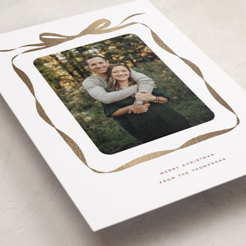 This is a nutmeg foil pressed holiday cards with foil pressed by Olivia Kanaley Inman called bow printing on recycled smooth signature in standard
