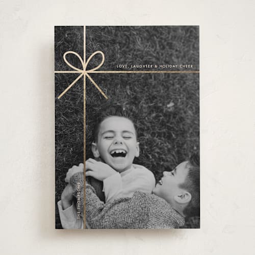 This is a champagne foil pressed holiday cards with foil pressed by Joyce Pinheiro called tied in cheer printing on recycled smooth signature in standard