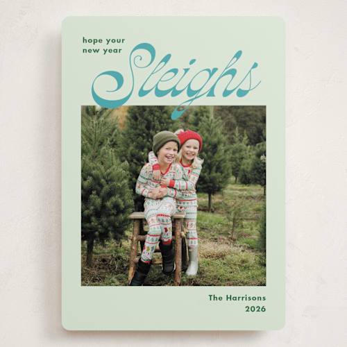 This is a turquoise holiday photo cards with standard by Megan Davis called sleighs printing on recycled smooth signature in grand