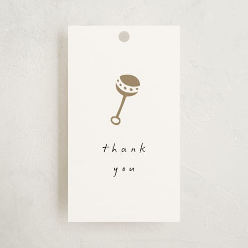 This is a cotton baby shower favor tags with standard by Stacy Maalouf called gold rattle printing on signature in tag