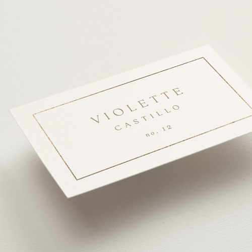 This is a golden wedding place cards with foil pressed by Kelly Schmidt called framed monogram printing on signature in placecard