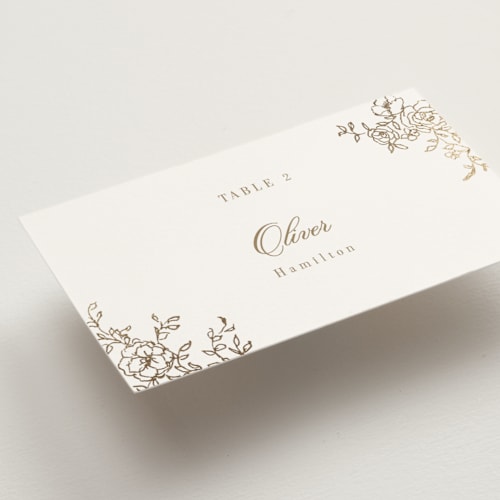 This is a champagne wedding place cards with foil pressed by Cass Loh called floral crest printing on signature in placecard