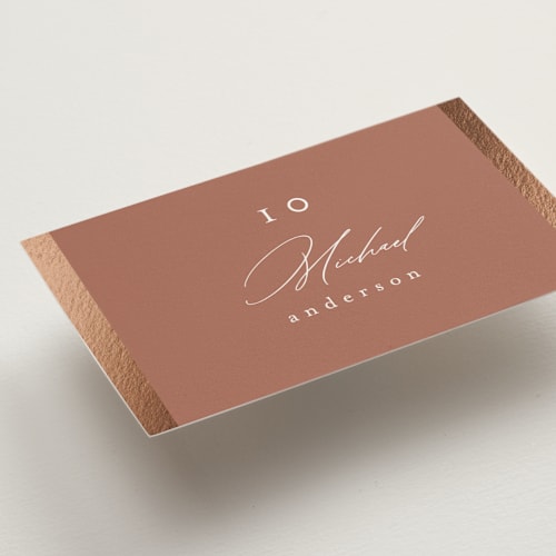 This is a terracotta wedding place cards with foil pressed by Nicole Walsh called surround printing on signature in placecard
