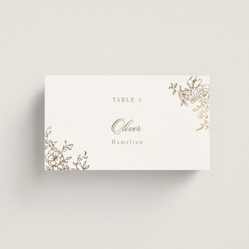 This is a champagne wedding place cards with foil pressed by Cass Loh called floral crest printing on signature in placecard