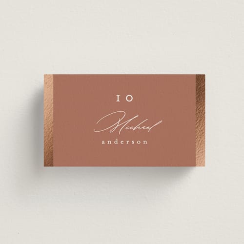 This is a terracotta wedding place cards with foil pressed by Nicole Walsh called surround printing on signature in placecard