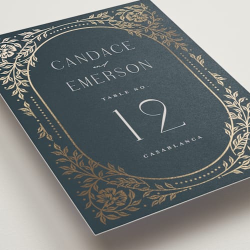 This is a navy table numbers with foil pressed by Ana de Sousa called gilded nouveau frame printing on doublethick in standard