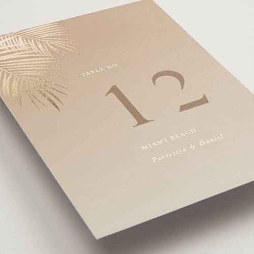 This is a tan table numbers with foil pressed by lulu and isabelle called sunset by the sea printing on doublethick in standard