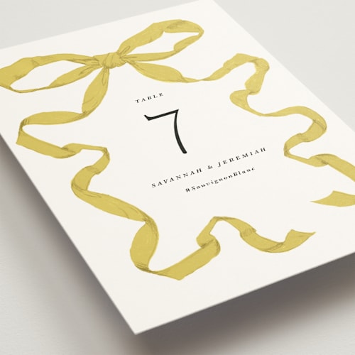 This is a citrine table numbers with standard by Olivia Kanaley Inman called antique ribbon printing on doublethick in standard