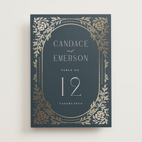 This is a navy table numbers with foil pressed by Ana de Sousa called gilded nouveau frame printing on doublethick in standard
