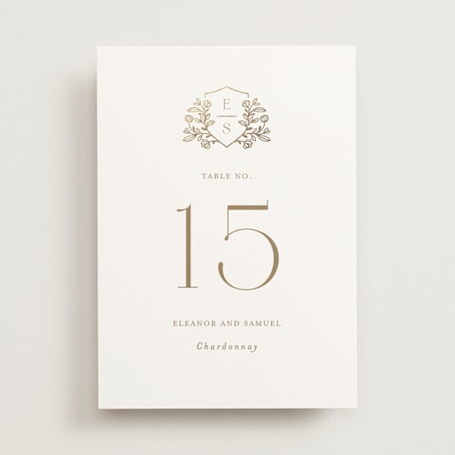 This is a ivory table numbers with foil pressed by Mansi Verma called gold crest printing on doublethick in standard