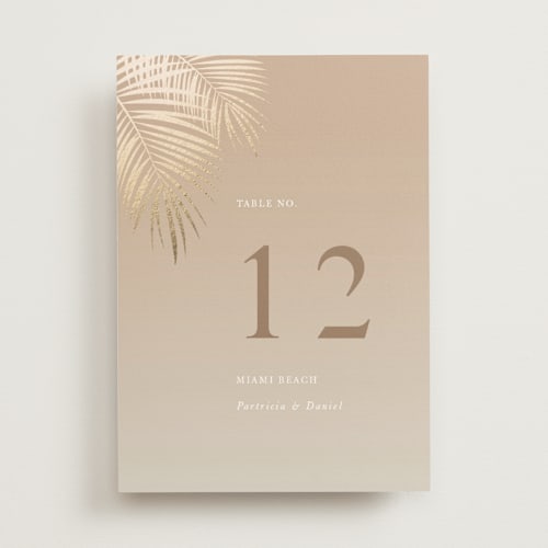This is a tan table numbers with foil pressed by lulu and isabelle called sunset by the sea printing on doublethick in standard