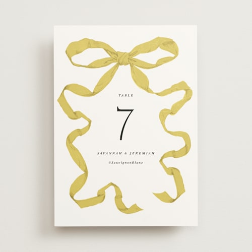 This is a citrine table numbers with standard by Olivia Kanaley Inman called antique ribbon printing on doublethick in standard