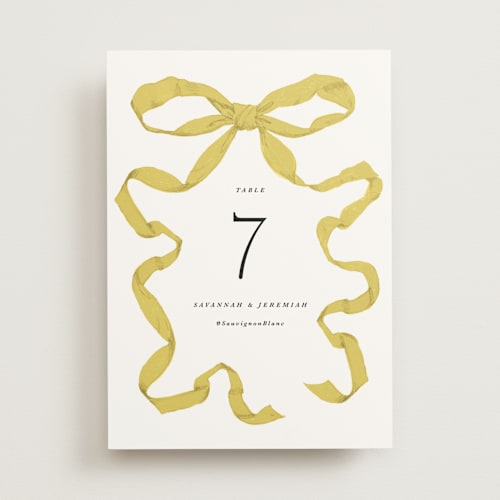 This is a citrine table numbers with standard by Olivia Kanaley Inman called antique ribbon printing on doublethick in standard