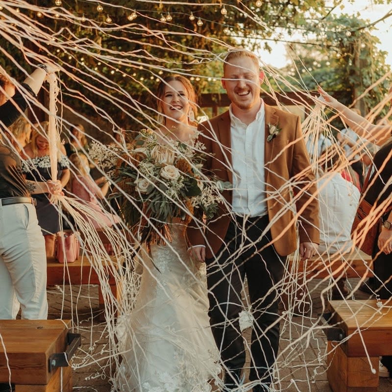 Couple walking the aisle in a shower of confetti